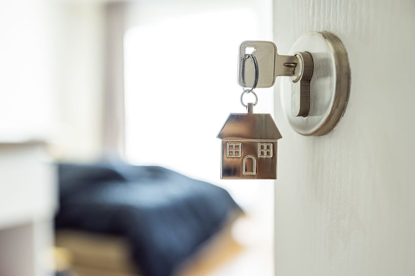 Open the door and door handle with a key and a keychain shaped house.