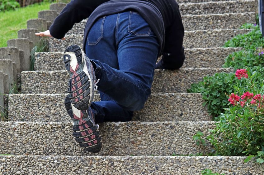 A woman slips on a staircase and fell down. a woman falling down a staircase